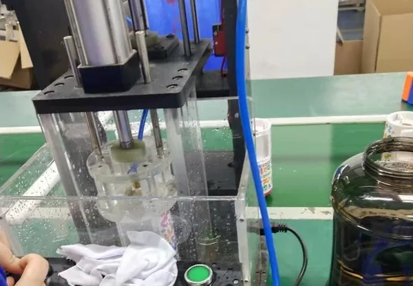 Stainless steel bottle undergoing controlled leak and sealing inspection